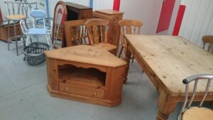 a table, tv stand and wooden chairs waiting to be stored away.